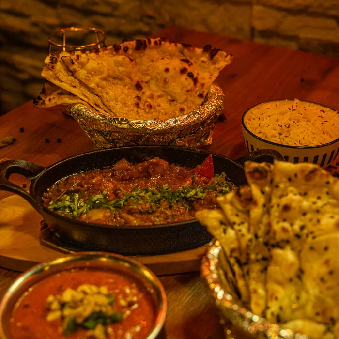 Naan, curry i dodatki na wspólnym stole